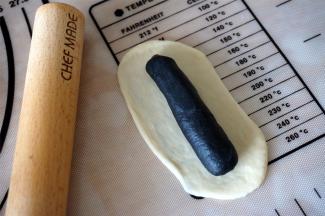 接着包白色的面团，这次的白色面团需要擀宽长一些，能把竹炭的完全包起来，接缝处捏紧。