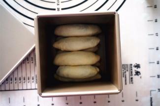 将包好的面团排入吐司盒，一盒12条面团，共两盒。