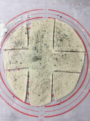 面饼上先刷一层玉米油，然后放上自己喜欢的黑芝麻、白芝麻盐。将面饼分成9块，不切断。