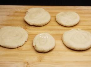 用手从中间压扁，油酥饼胚就做好了。