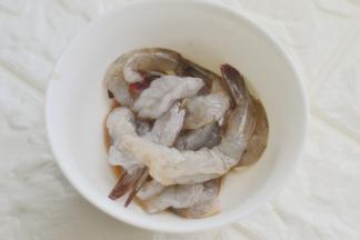 虾去头壳和肠线，用盐和料酒抓拿腌制5分钟后洗净，香肠切寸断、胡萝卜去皮切细条，鹌鹑蛋煮熟去壳