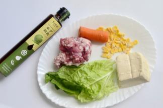 材料：肉泥150克 胡萝卜小半根 南豆腐一小块 玉米适量 辅料：白菜叶 调料：又伊鲜柚子胡椒色拉汁 盐 鸡精 料酒 糖 生抽少许
