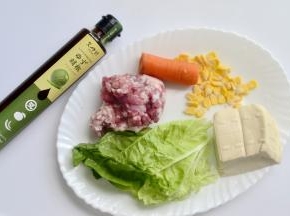 材料：肉泥150克 胡萝卜小半根 南豆腐一小块 玉米适量 辅料：白菜叶 调料：又伊鲜柚子胡椒色拉汁 盐 鸡精 料酒 糖 生抽少许