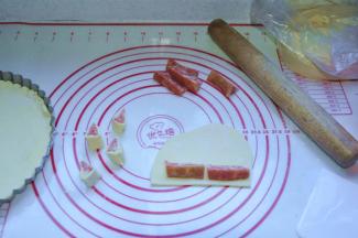 5、用面团包裹住火腿肠，用刀切成约2~3cm左右的长段；