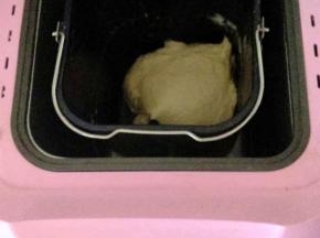 1、首先制作饼胚。将饼胚的全部材料放入面包机中，和面揉成一个光滑的面团；