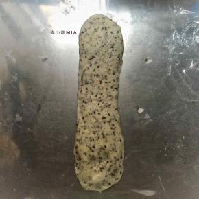 二次松弛好的面团擀成长舌状，由上往下卷起