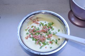 7、取3分之一的蛋白霜加入蛋黄糊中切拌均匀后倒回到蛋白霜中切拌均匀，加入火腿和韭菜。