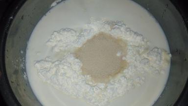 牛奶倒入面粉中，倒入酵母粉。新手可以先将酵母粉倒入牛奶中溶解，再倒入面粉中。