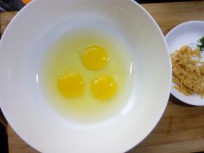 鸡蛋磕入碗中，打散。