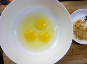 鸡蛋磕入碗中，打散。