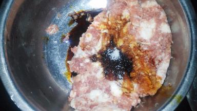 肉馅加入生抽、老抽、白糖搅拌均匀，分三次加入葱姜花椒水，顺时针搅拌上劲。（葱姜花椒水就是用从、姜、花椒一起泡的水）