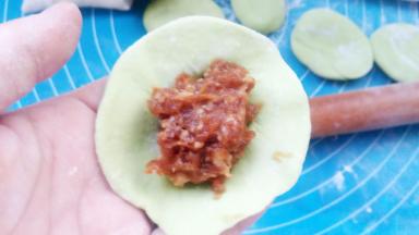 取一个小剂子，擀扁，包入肉馅儿。