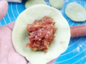 取一个小剂子，擀扁，包入肉馅儿。