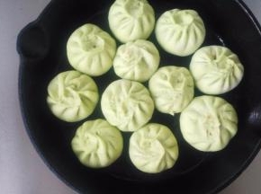 锅中倒油，比平时炒菜稍微多一汤匙的量。油热，放入包子。小火煎三四分钟，底部定型即可。