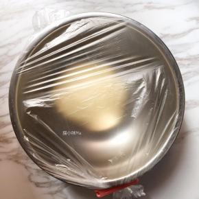 将揉好的面团放在盆子里，密封好，放在温暖处进行基础发酵