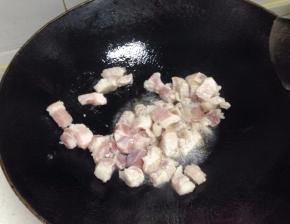 锅里放入少许油，倒入五花肉，炒至变色