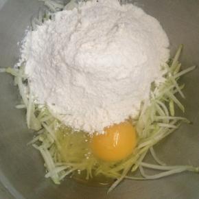 面粉中加入一个鸡蛋、西葫芦丝、少许盐。