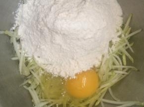 面粉中加入一个鸡蛋、西葫芦丝、少许盐。