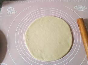 做完上面的准备工作，面团差不多发酵好了。擀成披萨盘大小，我的是九寸烤盘。