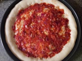 在饼胚上均匀涂抹好刚才炒好的披萨酱