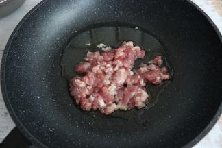 锅内留底油，放入瘦肉馅翻炒。