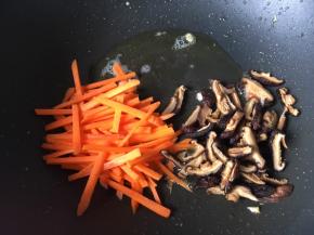 锅里下油炒胡萝卜和香菇，因为这两样难熟一点