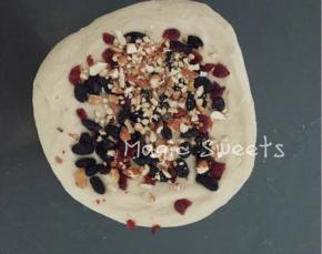 将酵母用水稍微化开，除黄油以外的材料混合揉成团，至揉至七八分膜状态，加入黄油继续揉，揉至能拉出均匀的薄膜，平铺加入果干和干果。