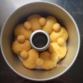 准备一个7寸的中空模具，为方便脱模，模具上刷一层黄油，醒发好的面团揉圆，放进模具中