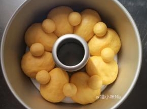 准备一个7寸的中空模具，为方便脱模，模具上刷一层黄油，醒发好的面团揉圆，放进模具中