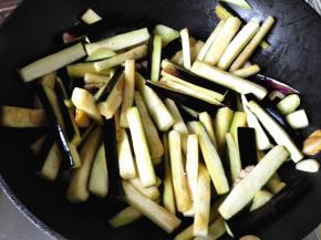 8.	倒入茄条翻炒，让茄条均匀的沾到油，