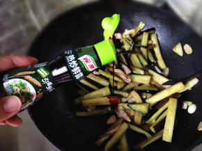 9.	待茄条变软了，倒入适量酱油接着翻炒，