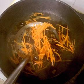 3.锅中烧沸水，先开水烫一下木耳，然后放胡萝卜丝，断生后捞出