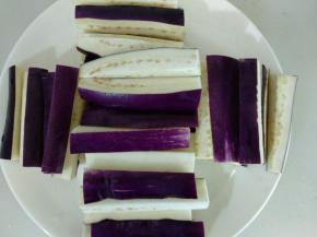 烧水期间，茄子洗净切成条摆入盘里。