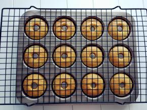 .稍晾凉后，用手将每个甜甜圈转动一下，方便脱模，将晾网盖在上面。