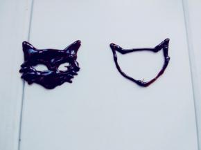 剩余的巧克力装入剪小口的裱花袋，在转印纸或板上画出小猫头部的轮廓。我是直接画的，如果拿不准比例的新手，可以先用笔画在纸上，垫在转印纸下方描绘。