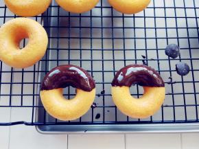 黑巧克力用微波炉融化，将甜甜圈蘸一下，放在晾网上凝固。