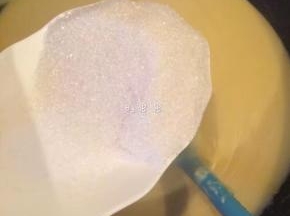 7、等到绿豆泥略干，加入白糖继续翻炒。