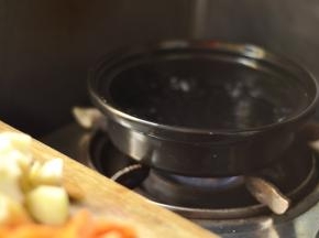 3、锅内加入清水煮开放入切好的土豆、胡萝卜