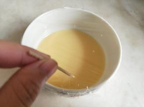 用牙签在保鲜膜上戳几个小洞。