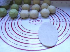 9、分别把包好的面团擀开，成牛舌形状，由上往下卷起来，收口朝下，放在面垫上
