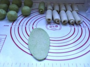 10、在把包好的酥皮2面团也擀开，成牛舌形状，由上往下卷起来，收口朝下，放在面垫上