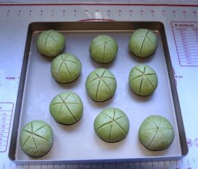 14、用刀片在包好的顶部对角切出六刀口，深度以切破面皮为宜，放入烤盘