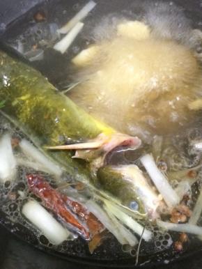 在把嘎牙鱼放入锅中