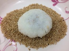 然后放在芝麻中，两边都均匀的沾上芝麻