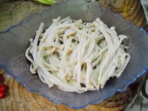 焯好的金针菇放入碗中。