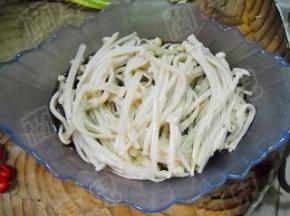 焯好的金针菇放入碗中。