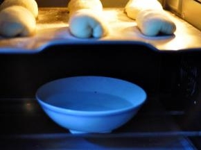 9、把烤盘放入烤箱中层，底层放一碗热水，开启烤箱发酵功能进行二发