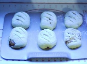 10、发酵好之后，取出来，筛上一层面粉，表面用刀片割口