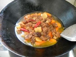 倒入压熟的牛腱肉和肉汁，炒匀；煮15分钟。