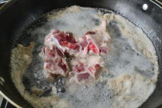 将大骨斩块放入冷水锅中烧开去污物，洗净